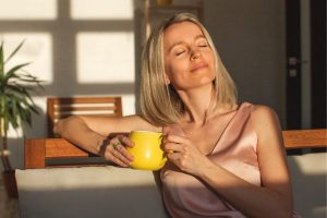 Woman in midlife relaxing with a cup of tea, illustrating calm and hormone balance in midlife.