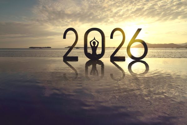 Person meditating inside the numbers “2026” at sunrise, symbolizing a calm and restorative New Year reset
