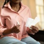 Woman holding menstrual products while managing heavy periods and menstrual health.